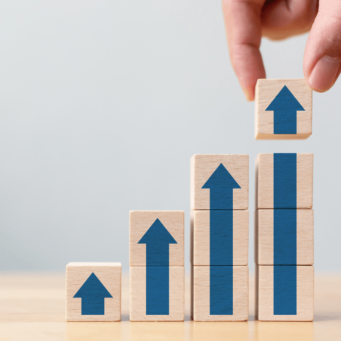 Wooden blocks with upward arrows illustrating the increase in Finland’s standard VAT rate.